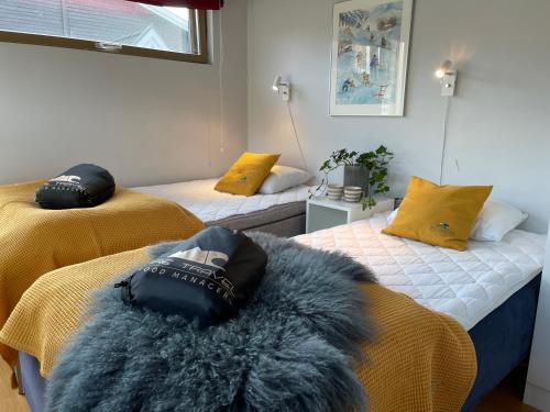 a room with two beds with a furry pillow on them at Åre Travel - Mörviksgården in Åre