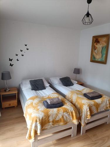 two beds sitting next to each other in a bedroom at Apartament Leśny in Supraśl