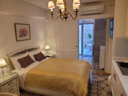 a bedroom with a bed and a chandelier at Tal-Kampjin in Mellieħa