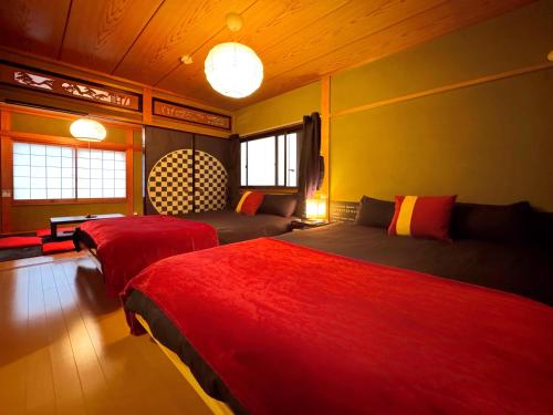 una camera con due letti, un divano e finestre di guesthouse中道 ad Osaka