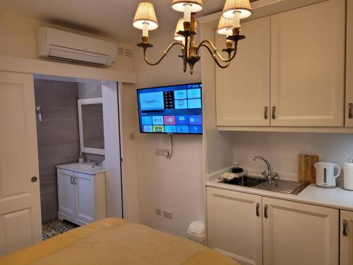 a kitchen with a sink and a tv on the wall at Tal-Kampjin in Mellieħa