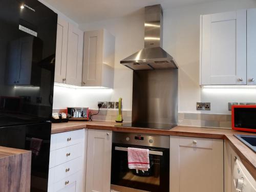 cocina con armarios blancos y fogones en Kings Road a new development with unique features, en Newbury