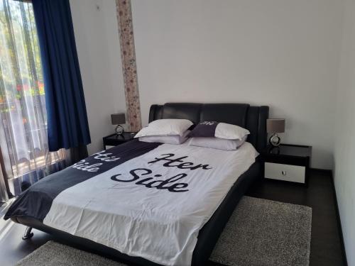a bedroom with a bed with a new smile sign on it at Pensiunea Agroturistica Diana in Măgura