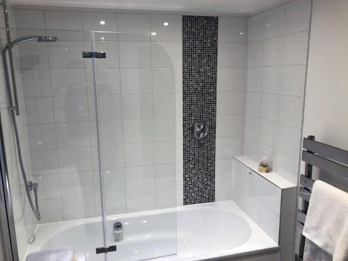 a bathroom with a shower and a bath tub at Crown House is a brand new development with unique features in Newbury