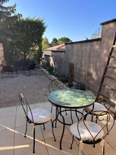 d'une terrasse avec une table et deux chaises. dans l'établissement Lou Atenéncia, à Villes-sur-Auzon