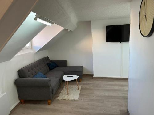 a living room with a couch and a table at Superbe appartement refait à neuf in Montlhéry