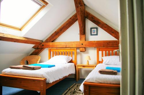a bedroom with two beds in a attic at Le Cerisier in Saint-Symphorien-de-Marmagne