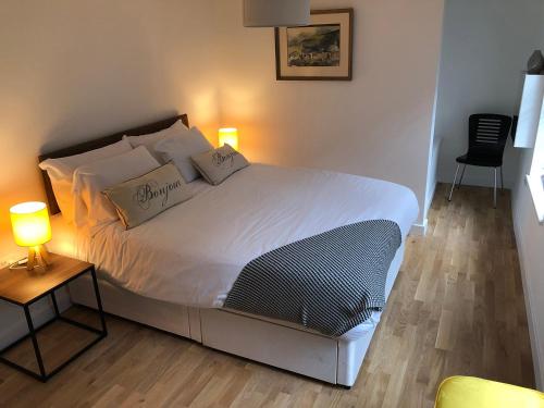 Schlafzimmer mit einem Bett mit weißer Bettwäsche und Kissen in der Unterkunft Crown House is a brand new development with unique features in Newbury
