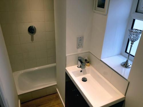 ein Badezimmer mit einem Waschbecken und einer Badewanne in der Unterkunft Crown House is a brand new development with unique features in Newbury