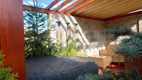 an outdoor patio with a large circular bed and plants at Lux Houses w DOMKU tylko DWA APARTAMENTYz jacuzzi zewnętrznym in Groń