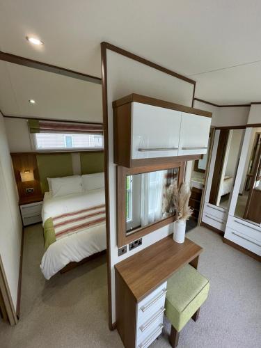 a bedroom with a bed and a large mirror at Golden Anchor - The Milano - Coastal Caravan Breaks in Chapel Saint Leonards