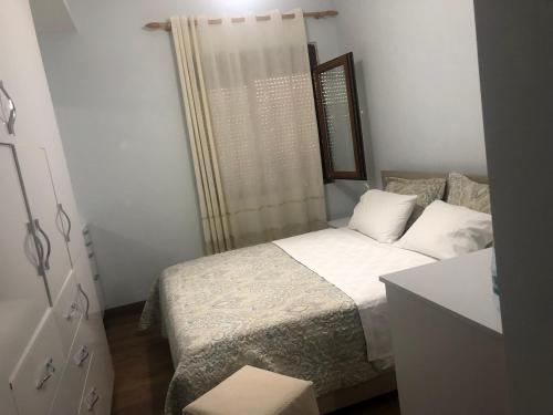 um pequeno quarto com uma cama e uma janela em Kris's apartment em Lezhë