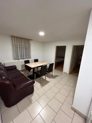 uma sala de estar com um sofá, uma mesa e cadeiras em Apartman Vanja em Pozega
