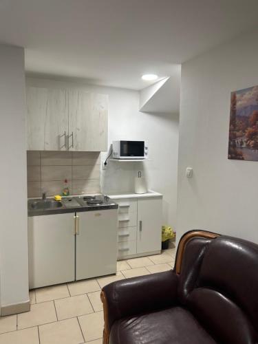 uma sala de estar com um sofá e uma cozinha em Apartman Vanja em Pozega