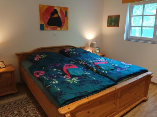Schlafzimmer mit einem Bett mit blauer Decke in der Unterkunft Ferienhaus am Wald in Sangerhausen