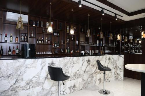 a bar with two black chairs and a marble counter at Green Park Hotel in Tashkent