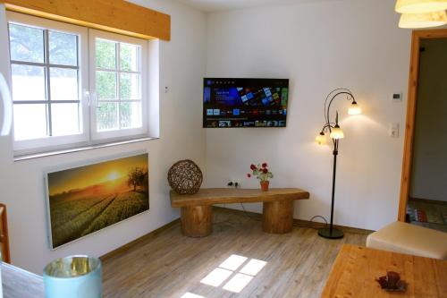 a living room with a bench and a tv at Ferienhaus am Wald in Sangerhausen