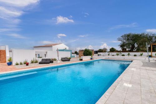 a swimming pool in front of a house at Quinta do Ourives in Carvoeiro