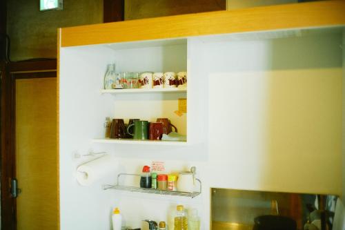 a kitchen with some shelves on the wall at Hostel&Bar CAMOSIBA in Yokote