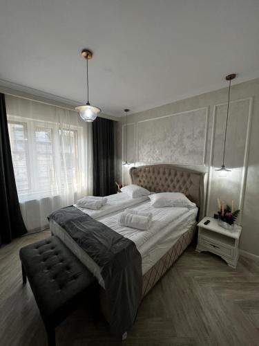 Un dormitorio con una cama grande y un banco. en Casa moderna situata in zona centrala a orasului en Tulcea