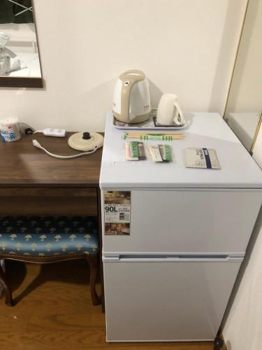 a desk with a phone on top of a refrigerator at HOSTEL198 in Osaka
