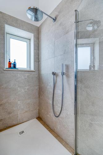 a shower in a bathroom with a glass shower stall at Quinta do Ourives in Carvoeiro