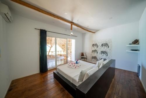 1 dormitorio con cama y ventana grande en Beachfront Villa Patti ZanzibarHouses, en Kiwengwa