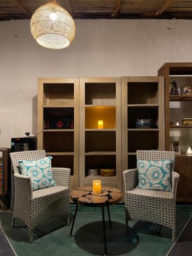 a room with two chairs and a table with a candle at Oemah Gebagan 78 Akasha Room B&B in Karangasem