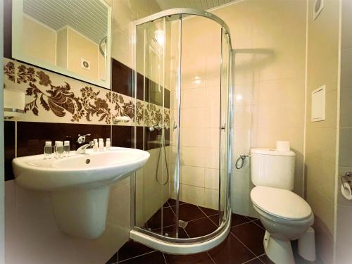 een badkamer met een toilet, een wastafel en een douche bij Apartments Stamopolu Lux with pool view in Primorsko