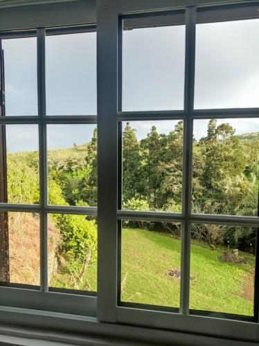 a window with a view of a field and trees at Villa Visconde in Nordeste