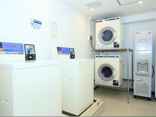 熊谷市にあるスマイルホテル熊谷の洗濯機、洗濯機、乾燥機が備わるランドリールーム