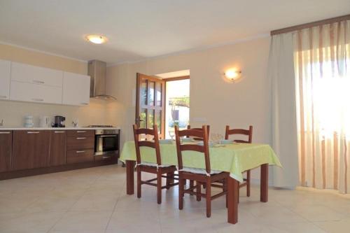 a kitchen and dining room with a table and chairs at Apartments Drpic in Gabonjin