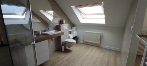 a bathroom with skylights and a toilet and a sink at Domaine du D-DAY in Saint-Côme-du-Mont