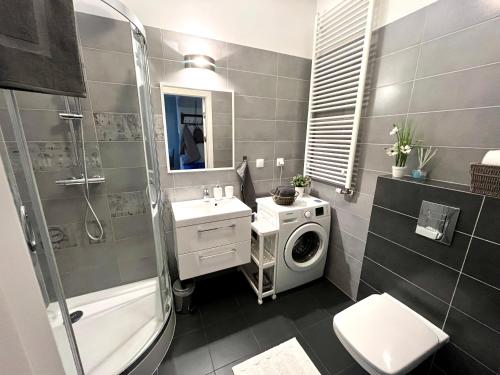a bathroom with a washing machine and a washer at Batalionów Apartment in Warszawa