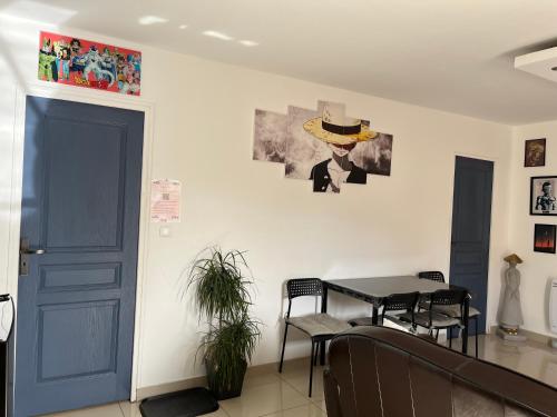 a dining room with a blue door and a table at maison entre Disneyland et Paris in Meaux