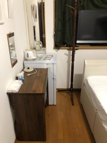 een kleine kamer met een bureau en een bed bij HOSTEL198 Private Room of Second floorーVacation STAY68024v in Osaka