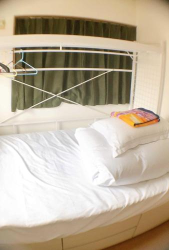 een wit bed met witte kussens en een raam bij HOSTEL198 Private Room of Second floorーVacation STAY68024v in Osaka