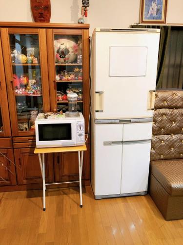 a microwave on a table next to a refrigerator at HOSTEL198 Private Room of Second floorーVacation STAY68024v in Osaka