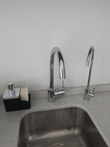 een gootsteen met twee kranen erop bij Palmas de Recoleta in Buenos Aires