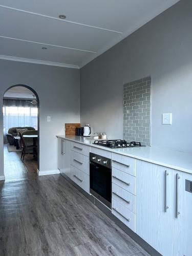a kitchen with white cabinets and a stove top oven at Goulden Street Guest House in East London
