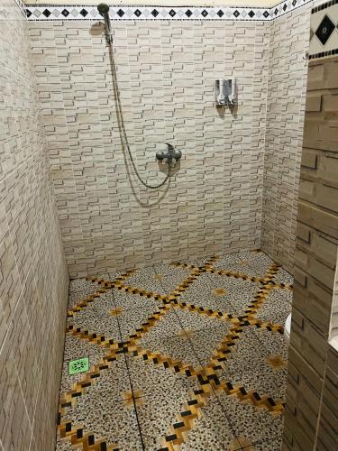 a shower with a mosaic floor in a bathroom at Kastapar Bridge Lembongan in Nusa Lembongan