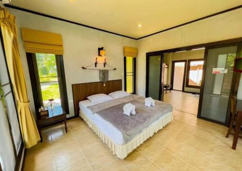 a bedroom with a large bed with towels on it at Waterjade Resort in Phangnga