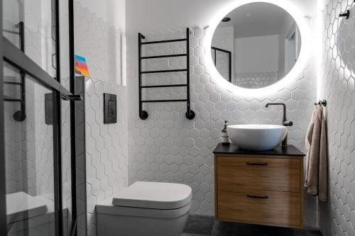 a bathroom with a sink and a toilet and a mirror at Industrial Luxury City Loft in Gothenburg