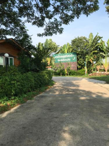 une route devant un bâtiment avec un panneau dans l'établissement Sripiamsuk Resort Bangkok, à Pathum Thani
