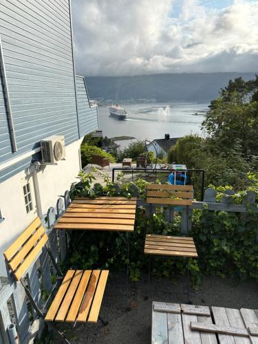 two wooden benches sitting on the side of a building at Great place with view to the mountains and fjord in Ålesund