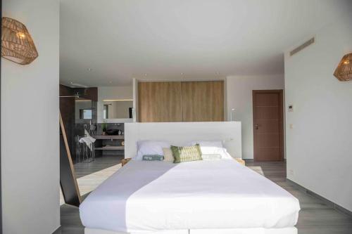 Cette grande chambre comprend un grand lit blanc. dans l'établissement Ivona Vacances - Villa de luxe avec piscine chauffée à Santa-Giulia, à Porto-Vecchio
