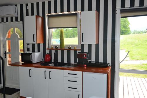 uma cozinha com armários brancos, uma janela e um balcão em Niesamowita Dolina 