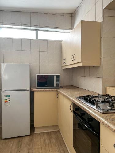 a kitchen with a white refrigerator and a microwave at Goulden Street Guest House in East London