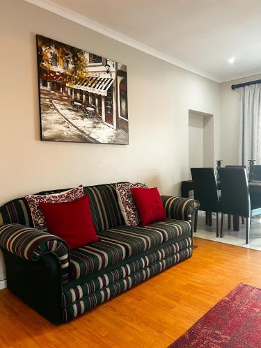 a living room with a couch with red pillows at Goulden Street Guest House in East London