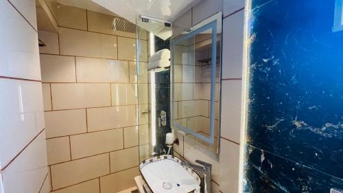 a bathroom with a toilet and a mirror at Home2 Renaissance Club in Mumbai
